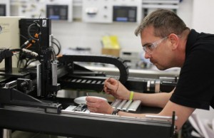 Alan Down, a senior in mechanical engineering technology at the College of Technology and Innovation, tests the electrical current in a micromilling machine his team has built from scratch. The team will display the machine at the Innovation Showcase that will be held May 1 on ASU's Polytechnic campus