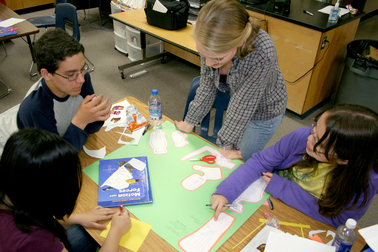 8thGrade_Prosthetics_large Eighth-grade Kyrene students Maclain Bonfield (left) and Alison Romero (right) discuss their prosthetic design with project team member Linda Nguyen. Standing is ASU biomedical engineering doctoral student Christine Zwart.