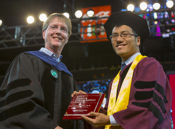 Photo of Hoi-To Wai holding a plaque next to Kyle Squires. Caption: Hoi-To Wai received the 2017 Dean's Dissertation Award from Dean Kyle Squires at the Fulton Schools' Fall 2017 Convocation. Photographer: Jessica Hochreiter/ASU