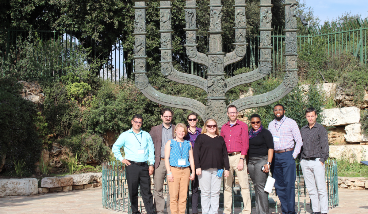 Group of people standing in front of large Menorah sculpture. Caption: The group in front of a large Menorah sculpture near the Israeli Parliament building. Photograph courtesy of Jeremi London/ASU