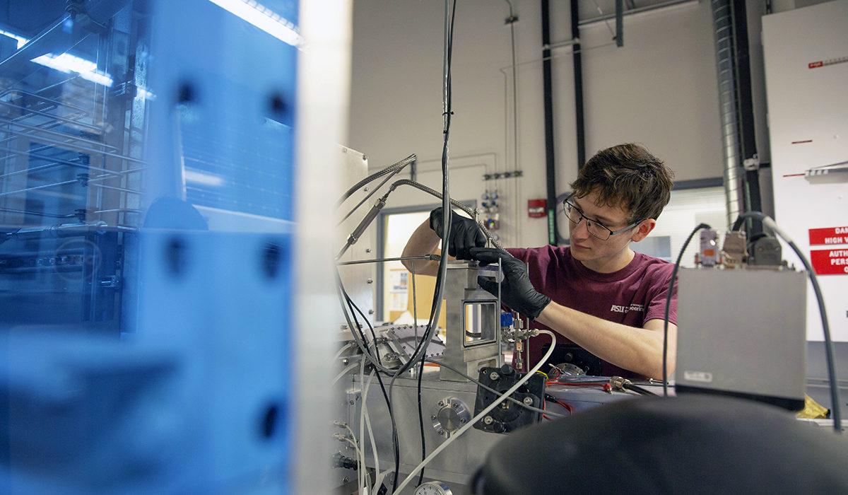 Photo of a student working in a lab. Caption: Electrical engineering senior Nathan Rodkey studies a thermally insulating coating for windows that will help reduce energy costs in buildings and homes as a researcher in Assistant Professor Zachary Holman’s lab. He helped Holman determine the properties of transparent, porous silica films. Photographer: Jessica Hochreiter/ASU