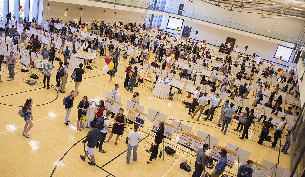 Overhead photo of posters in a gym. Caption: More than 200 student researchers presented their projects at the Spring 2018 FURI Symposium. Students conduct hands-on research in the labs of the Fulton Schools’ world-renowned faculty to help solve real-world challenges in health, sustainability, energy, security and education. Photographer Marco-Alexis Chaira/ASU