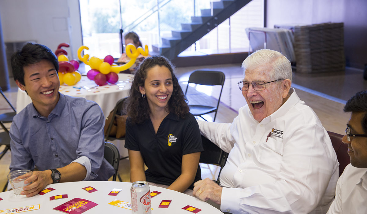 Photo of students sitting at a table with Ira A. Fulton. Caption: Ira A. Fulton attended the FURI Symposium to meet with undergraduate and graduate students as they present their research projects. The FURI program has been made possible by the generous support of the Fulton family. Photographer: Jessica Hochreiter/ASU