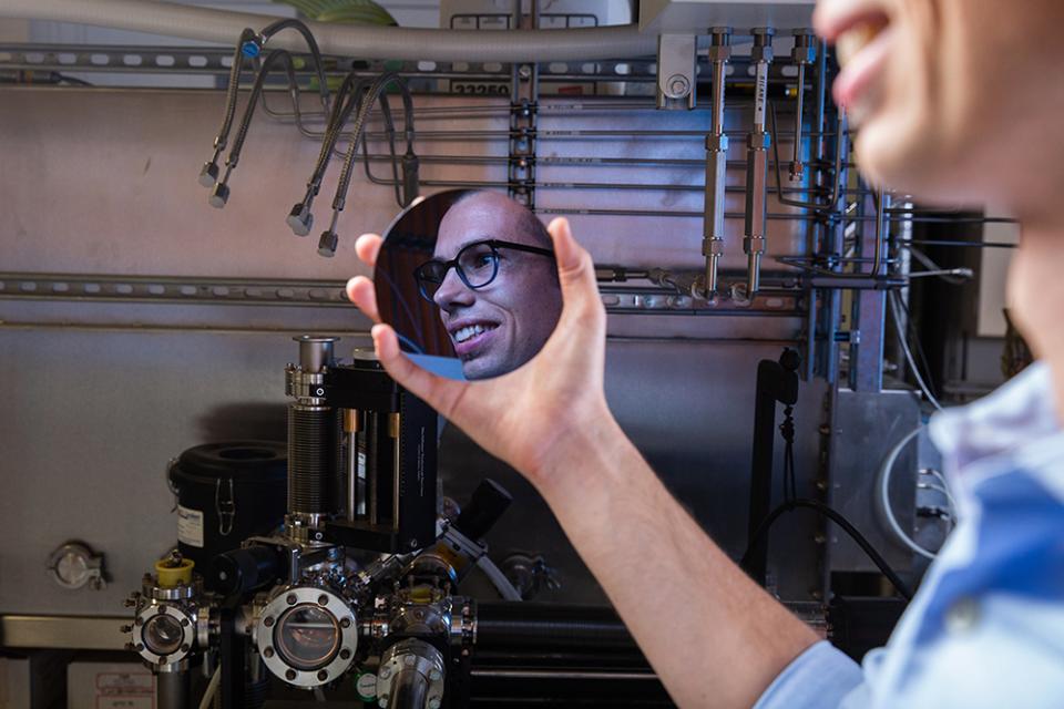 Photo of a man holding an object with his reflection in it
