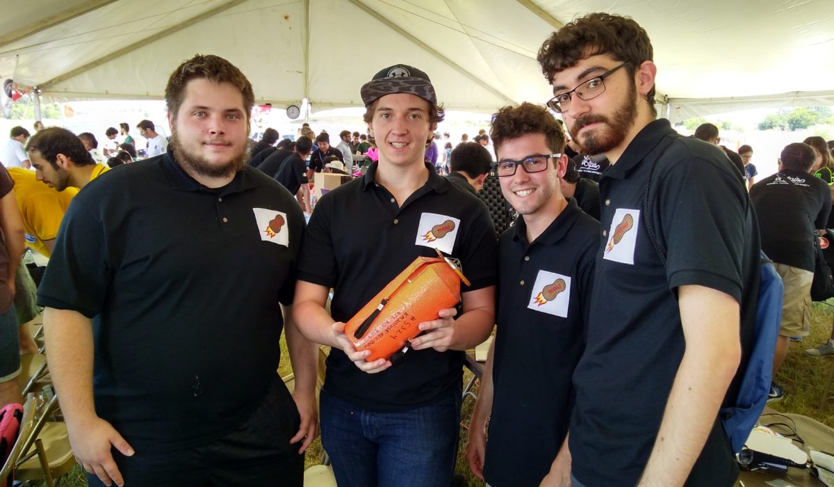 four students holding an object