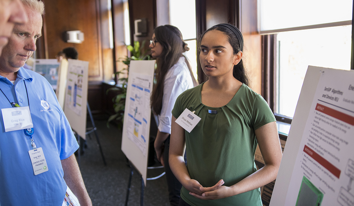 student standing in front of poster