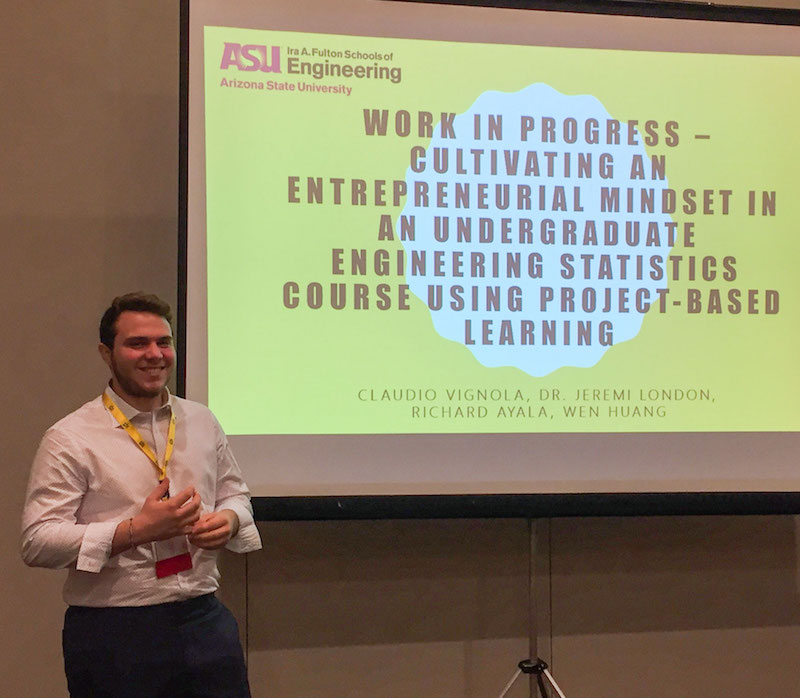 student standing in front of a large screen