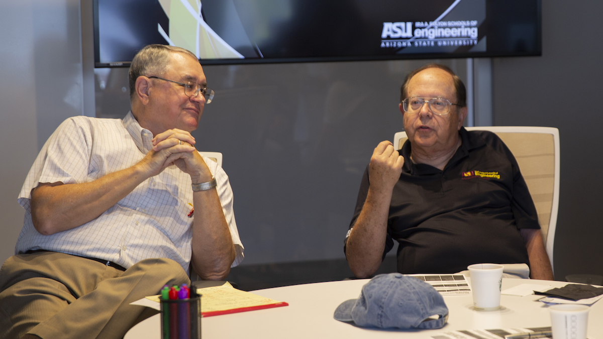 two men seated in chairs