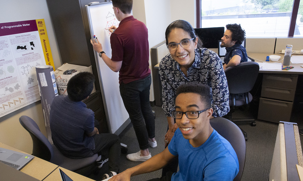 Professor standing behind a seated student