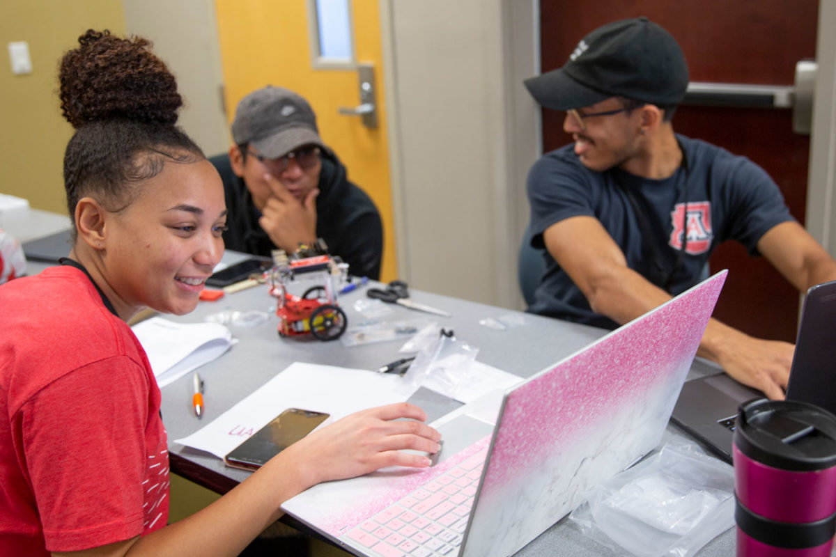 students working on robot and laptop