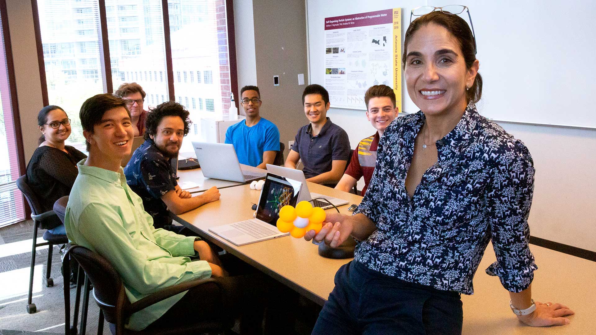 Andrea Richa standing in front of a table full of students