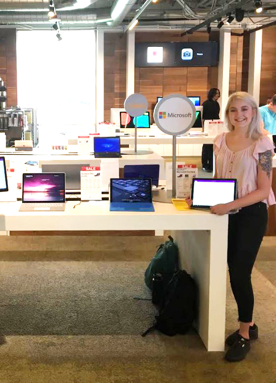 Ira A. Fulton Schools of Engineering electrical engineering alumna Mary Byron poses with a collection of Microsoft devices.