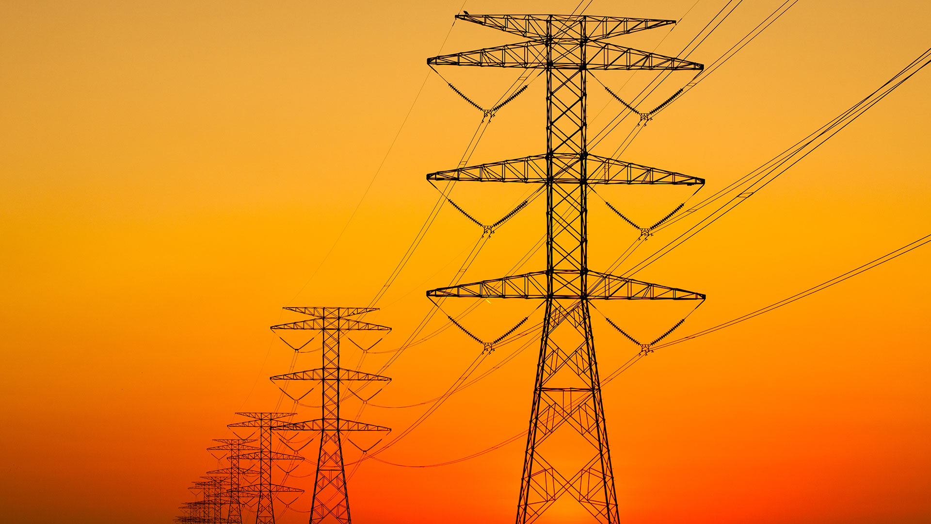 powerlines in front of a orange sky caused by wildfires