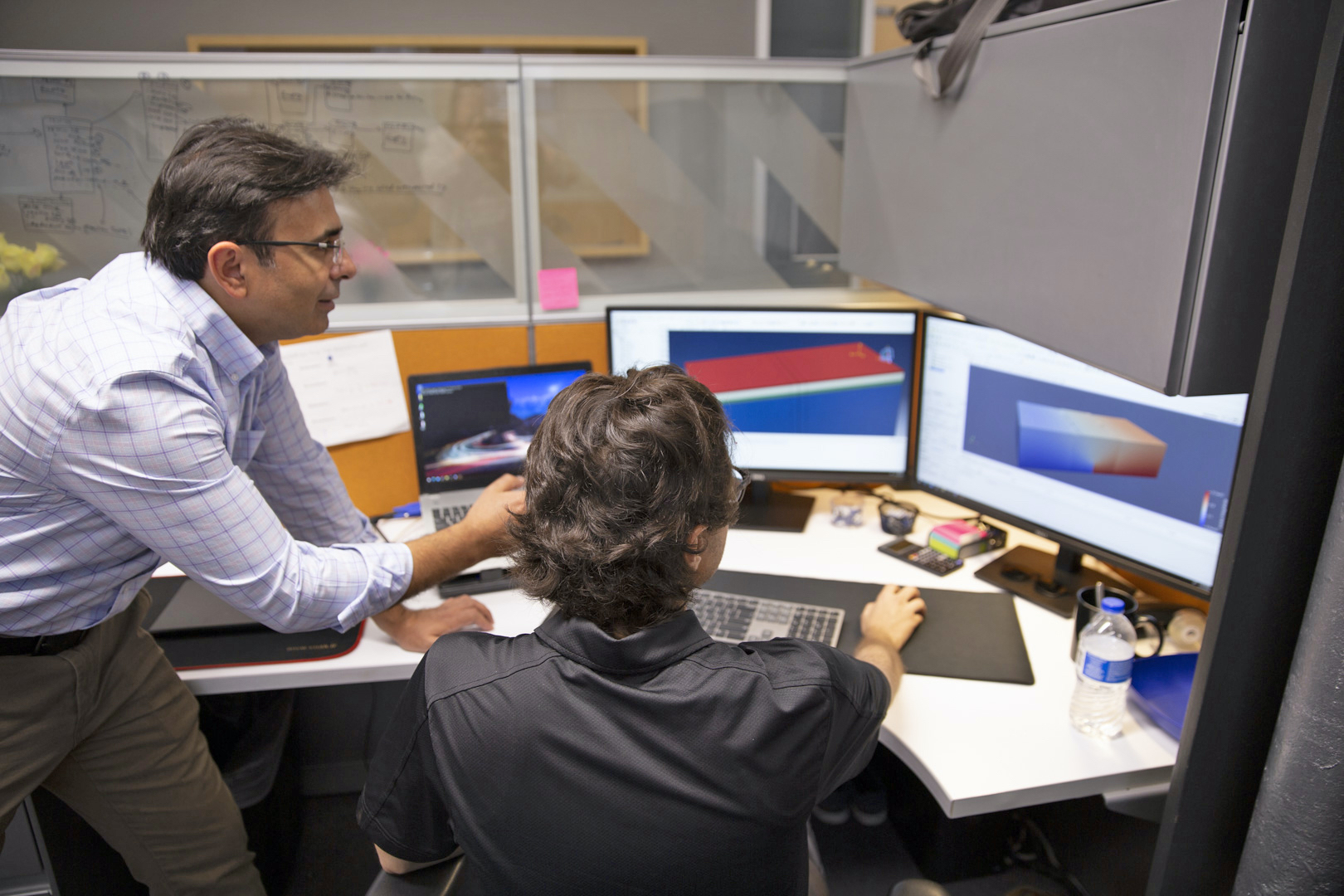 Hasan Ozer talking with a student at a computer
