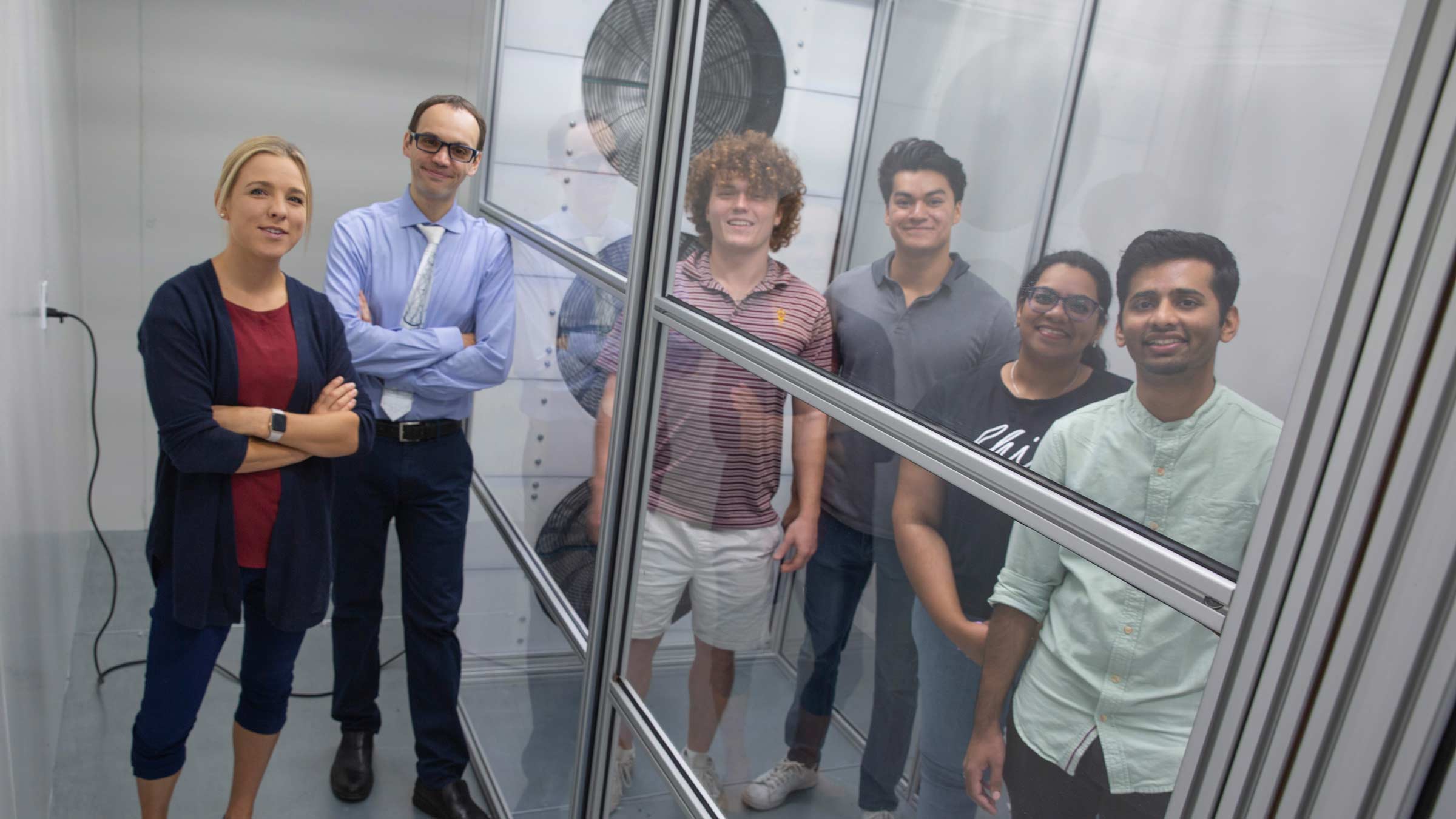 four students posing inside a test chamber