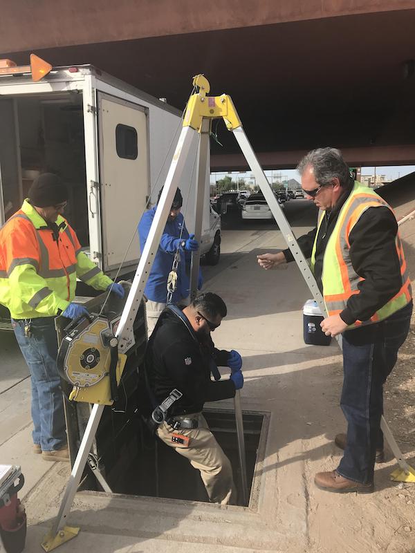 workers removing wastewater samples