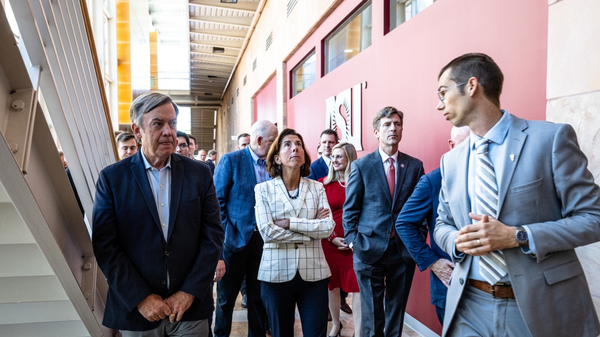 Arizona State University Associate Professor Zachary Holman (right) leads a tour of the MacroTechnology Works at the ASU Research Park in Tempe on Aug. 30. The tour showcased the university's and the Valley’s commitment to making Arizona a manufacturing hub for microchips. U.S. Sen. Mark Kelly, U.S. Secretary of Commerce Gina Raimondo (center), President Michael Crow (left), U.S. Rep. Greg Stanton (second from right) and other dignitaries talked about the recently signed CHIPS and Science Act of 2022 that will provide more than $50 billion for subsidies to build chip plants in the U.S.