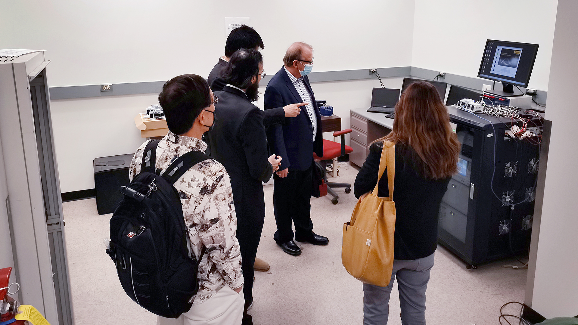 A group of ICRDE researchers looks at a computer for their research collaboration