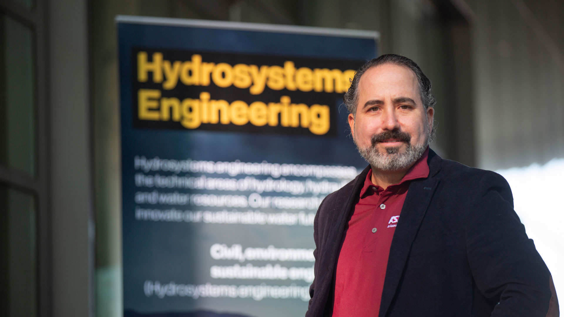 Enrique Vivoni in front of a banner that says Hydrosystems Engineering.