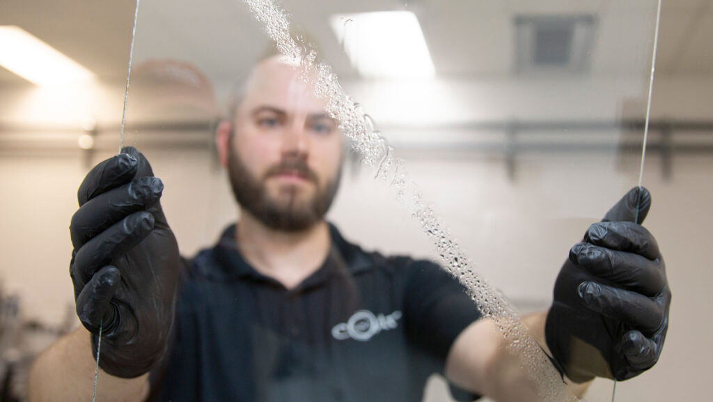 Swift Coat co-founder Peter Firth holds up an example of a glass panel with the company’s self-cleaning coating.