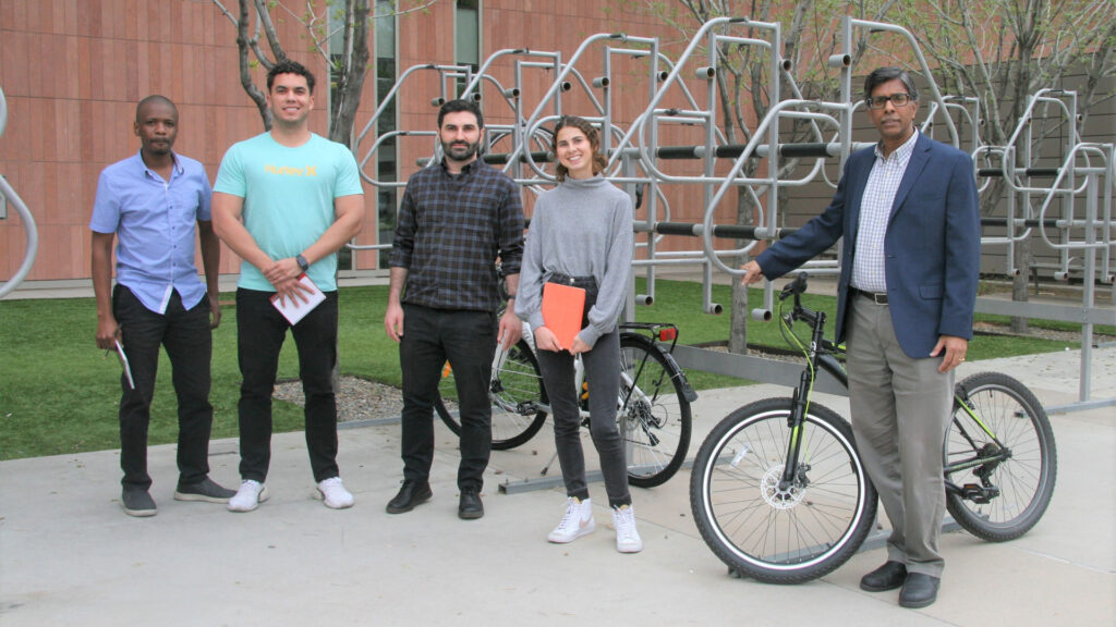 TOMNET researchers standing next to a bicycle